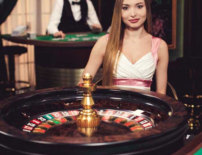 Girl sitting behind the roulette wheel