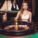Girl sitting behind the roulette wheel
